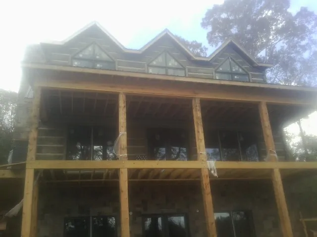 Dormers and porch framing on a large log home under construction — Roof Coating work by our crew in Housatonic
