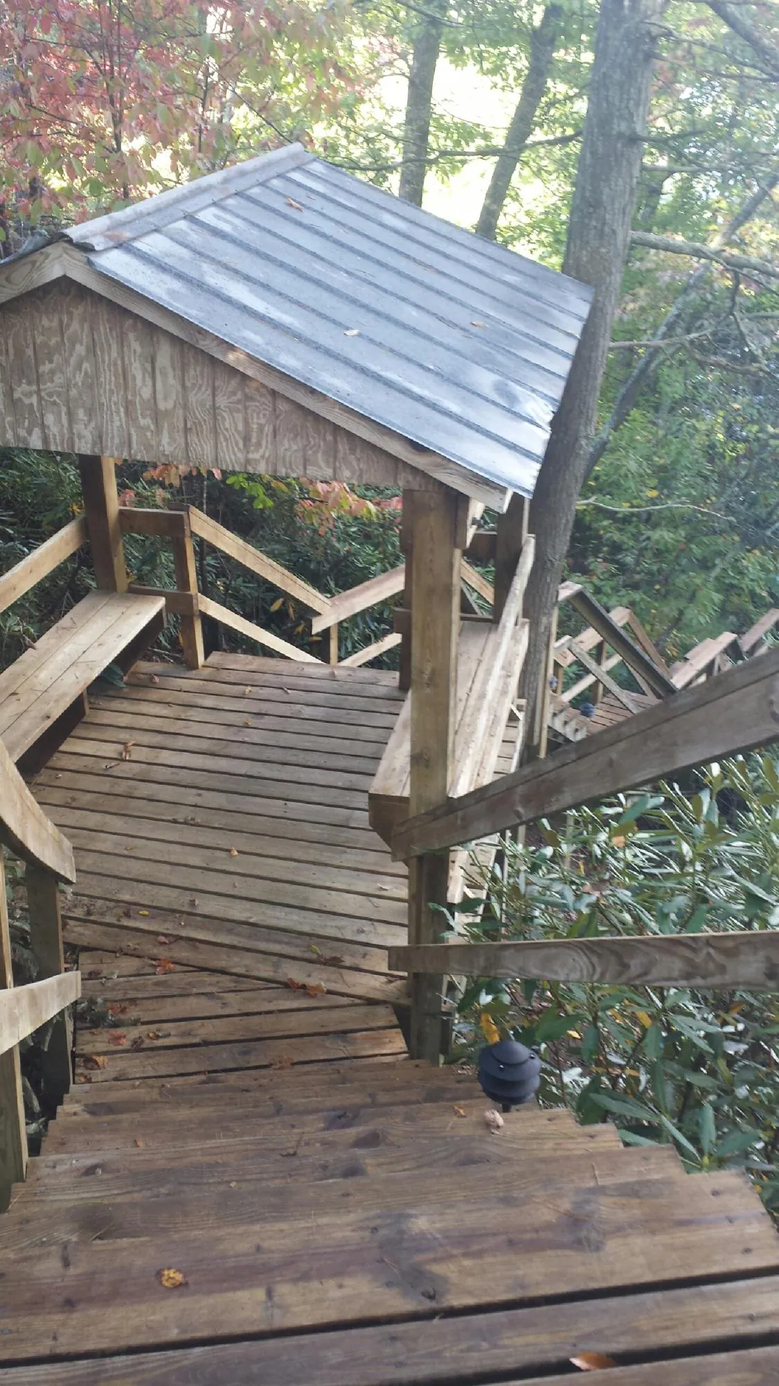 Metal roofed shelter over wooden steps on a wooded walkway — Skylight Repair & Installation work by our crew in Housatonic