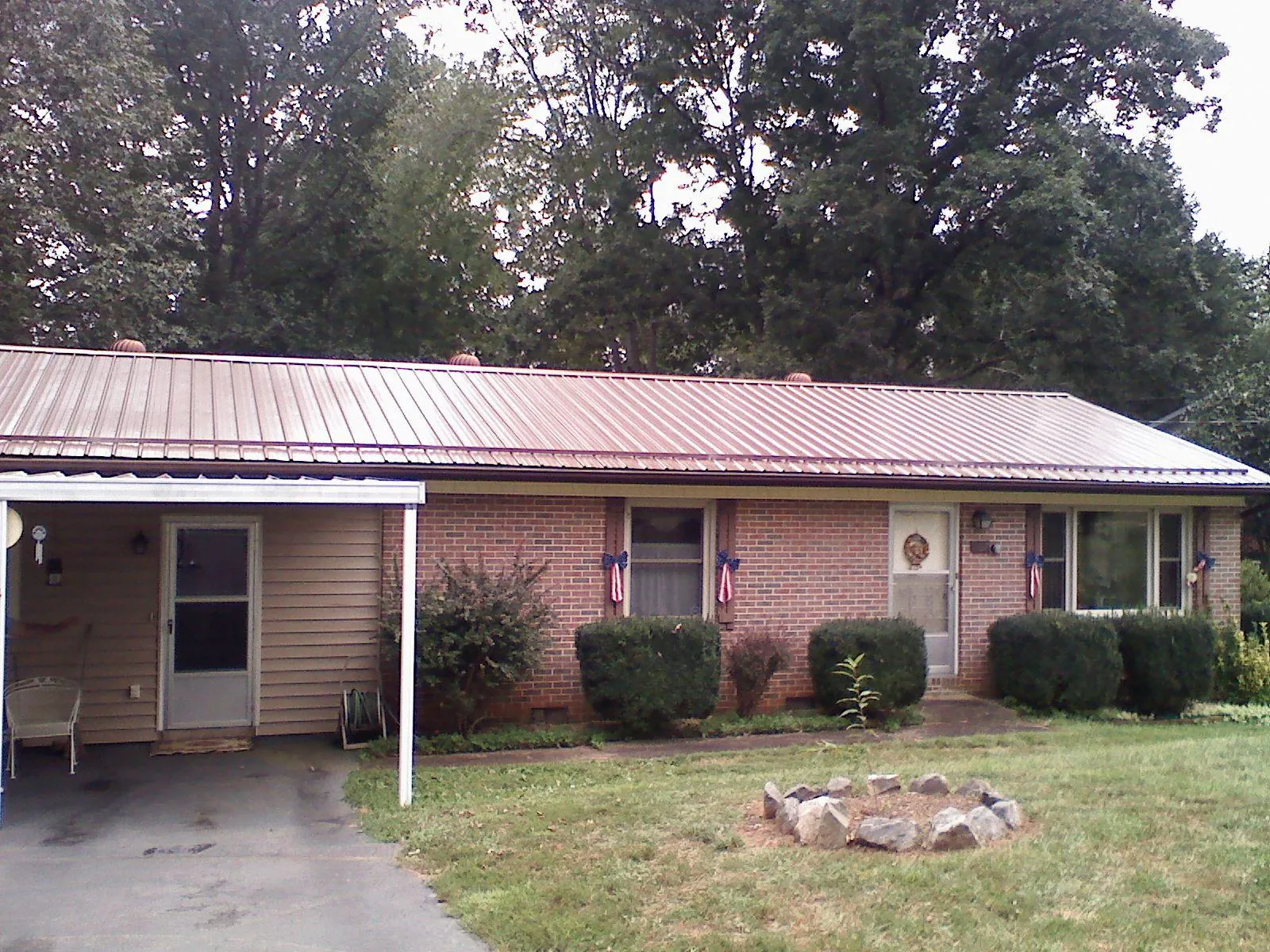 Bronze metal roof and carport on a brick ranch home — Roof Repair work by our crew in Housatonic